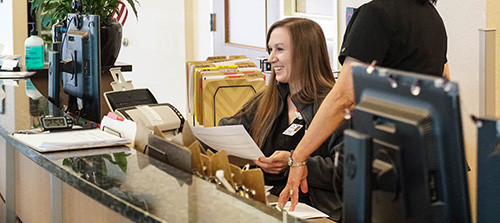 Female worker at reception desk for CNSA Female worker at reception desk for CNSA