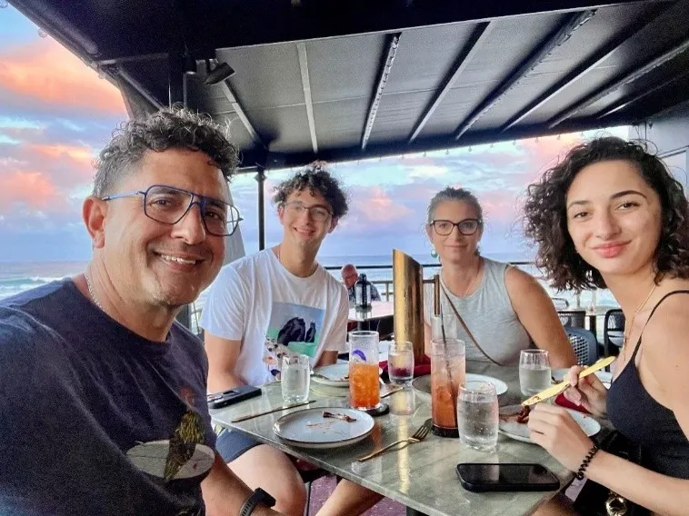 Rafael and his family enjoying dinner on an outdoor restaurant patio